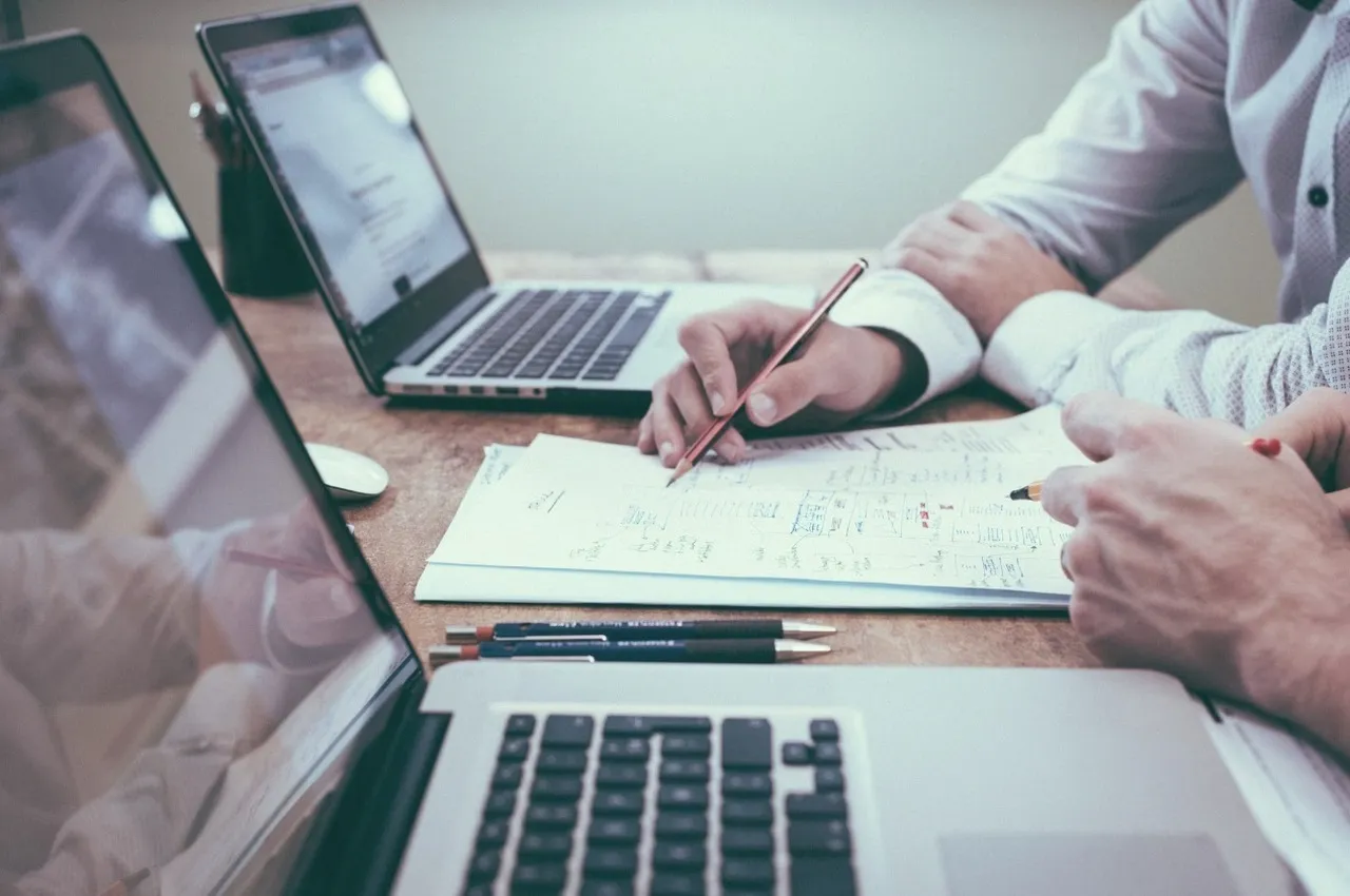 Zwei Geschäftsleute arbeiten zusammen mit Laptops